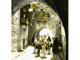 Alleyways in Jerusalem are narrow and so houses have been extended by building across the street, thus forming a series of arches. An early photograph.